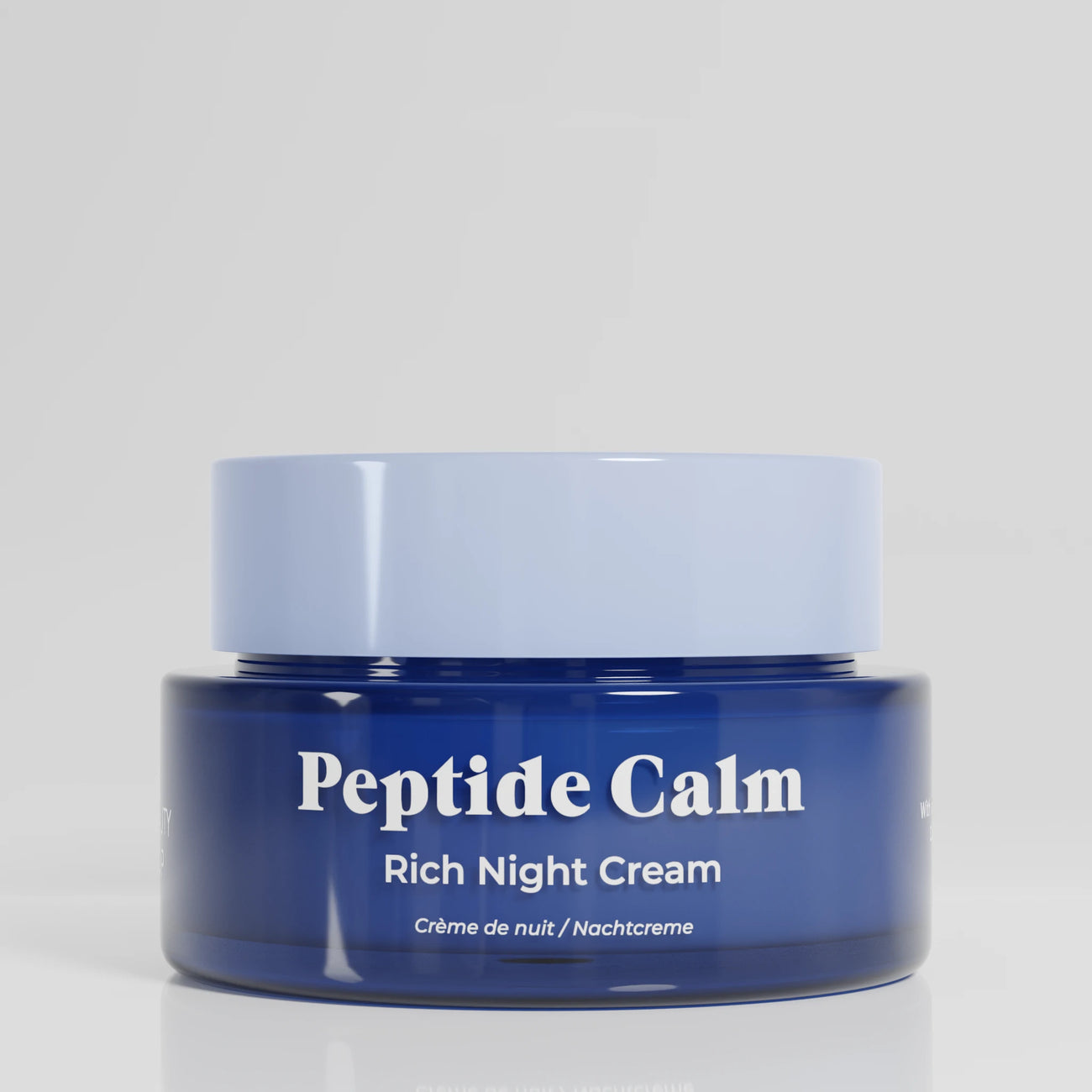 Blue jar of 'Peptide Calm' rich night cream on a light gray background
